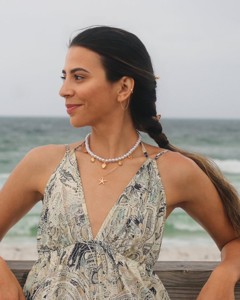 Karina, founder of Pretty Booked, smiling by the ocean